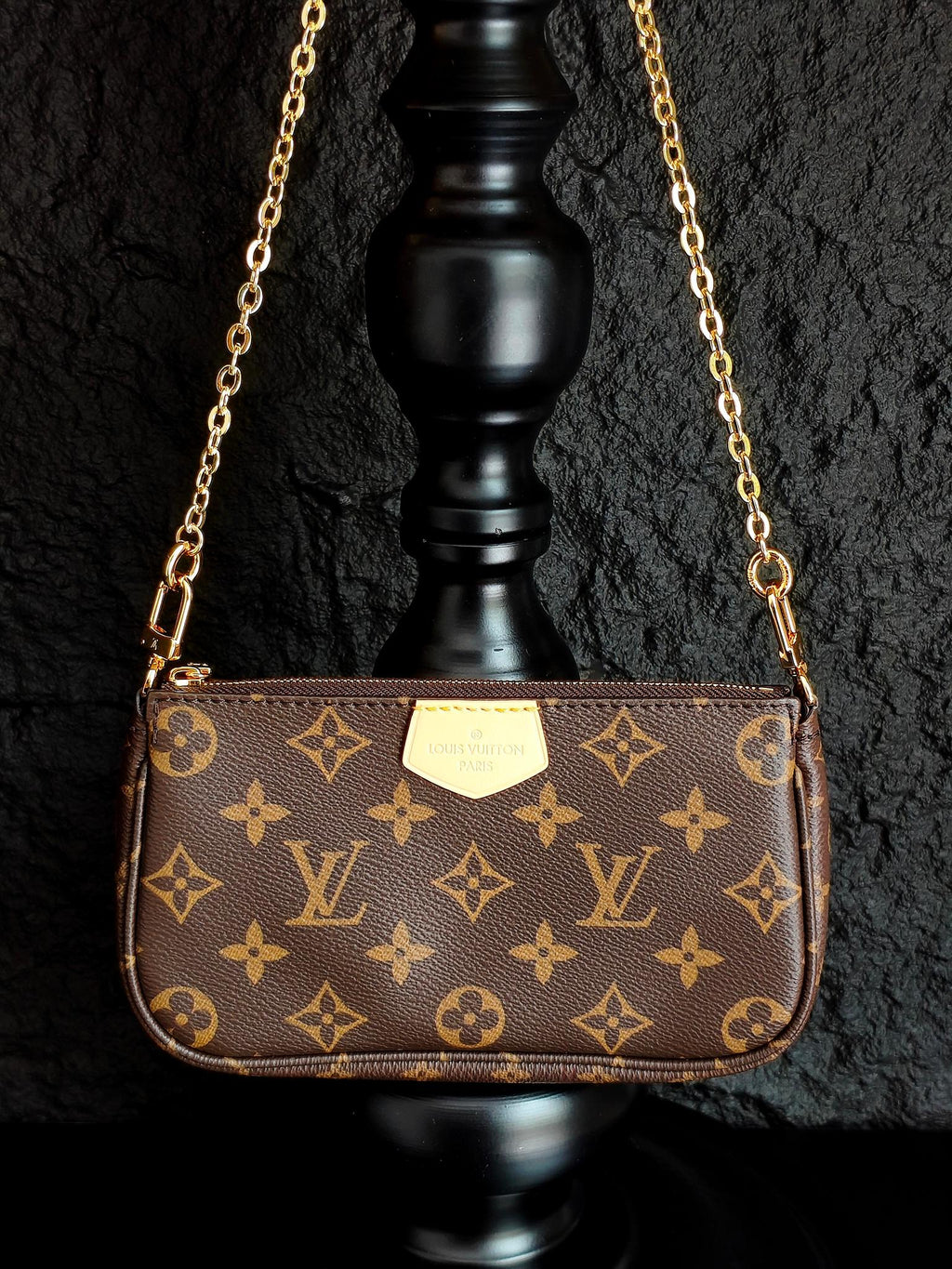 Louis Vuitton crossbody bag with monogram canvas and gold chain strap, centered front