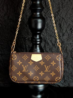 Louis Vuitton crossbody bag with monogram canvas and gold chain strap, centered front