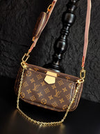 Louis Vuitton crossbody bag with monogram canvas, gold chain strap, and zippered front view