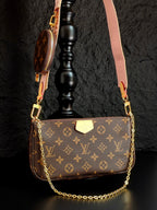 Louis Vuitton crossbody bag with monogram canvas, gold chain, and pink shoulder strap