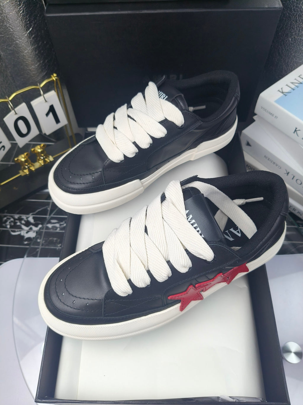 Navy low-top sneakers with white laces, pair displayed on box