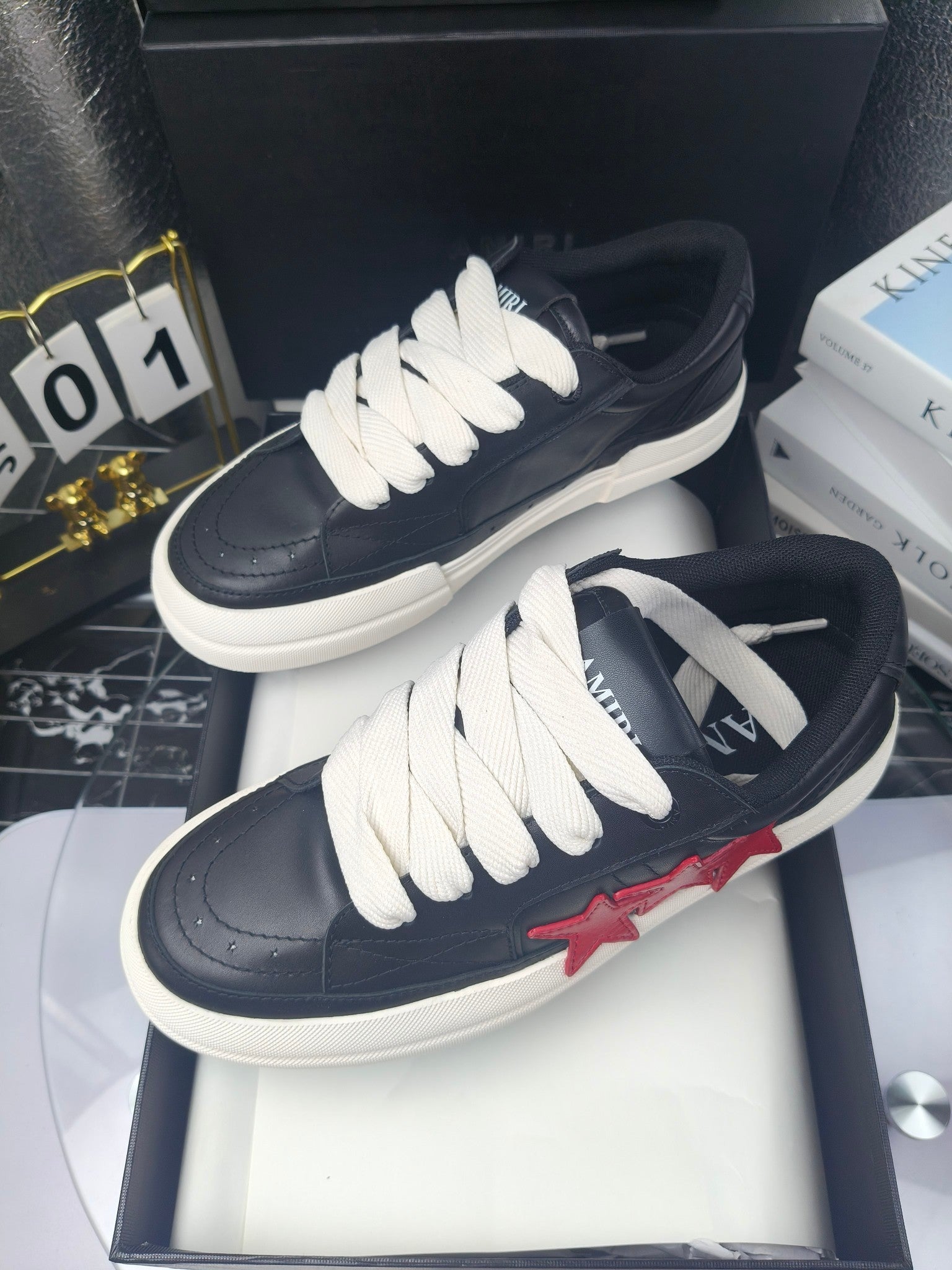 Navy low-top sneakers with white laces, pair displayed on box