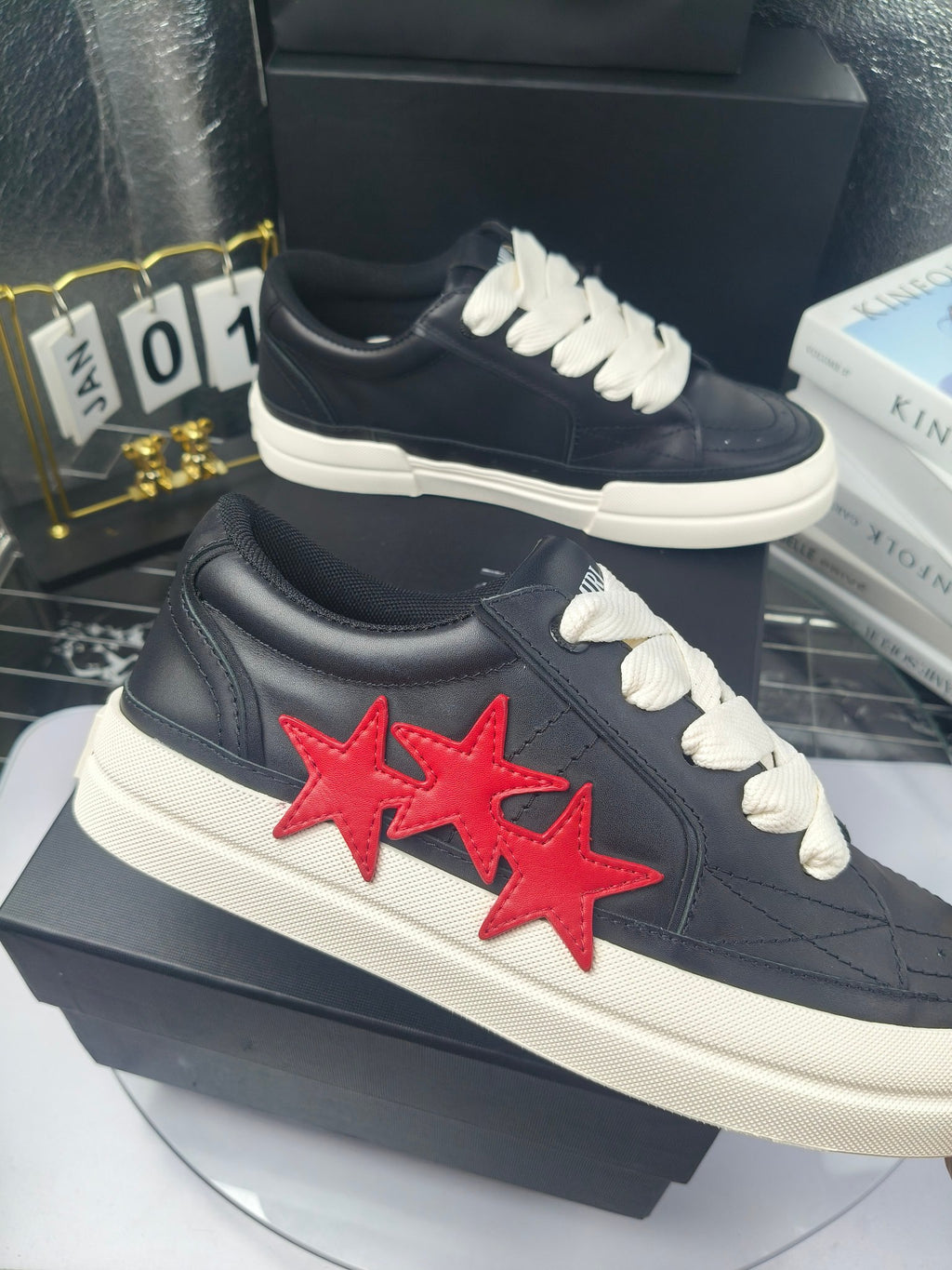 Navy low-top sneakers with white laces and red twin-star patch, white sole