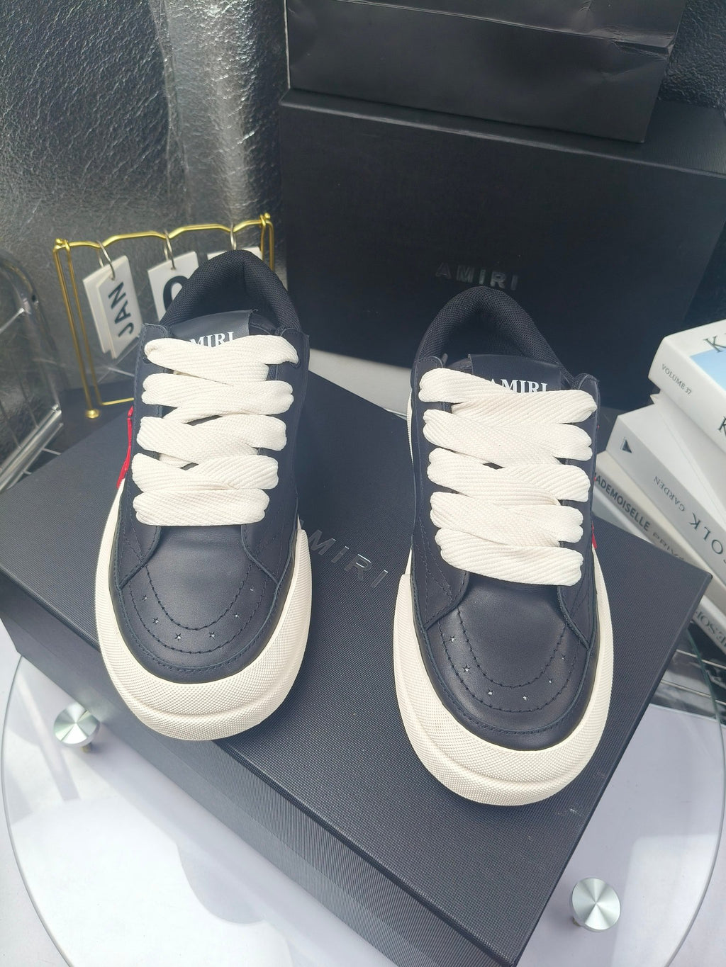 Navy low-top sneakers with white laces and textured toe seams