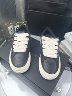 Navy low-top sneakers with white laces and textured toe seams