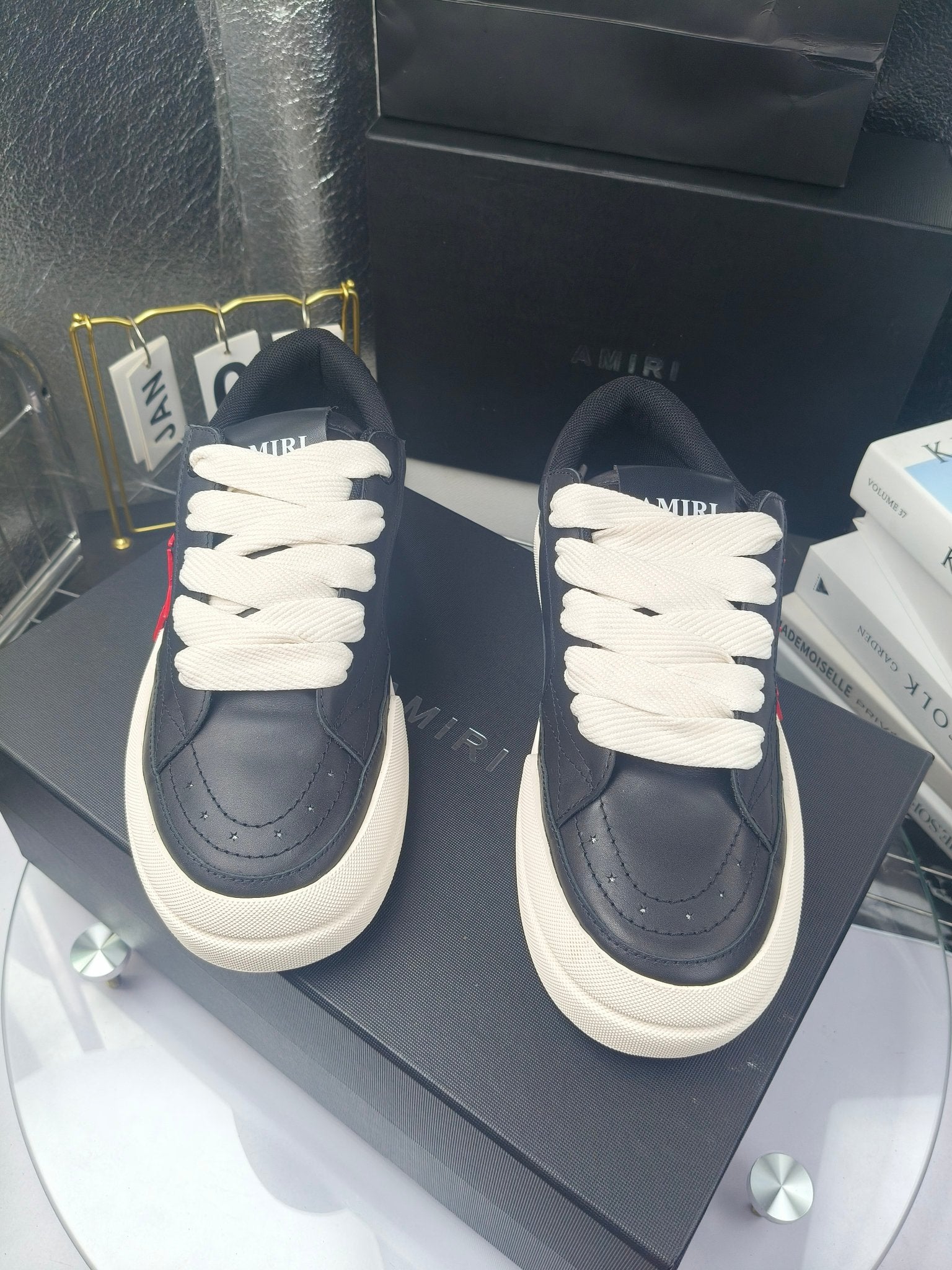 Navy low-top sneakers with white laces and textured toe seams
