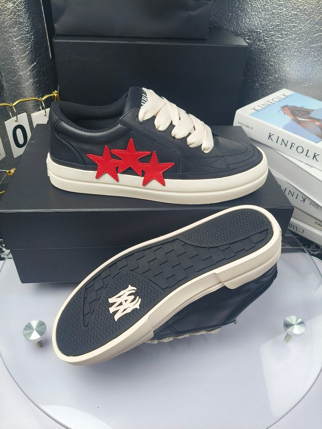 Navy low-top sneakers with white laces and red triple-star patch, white sole