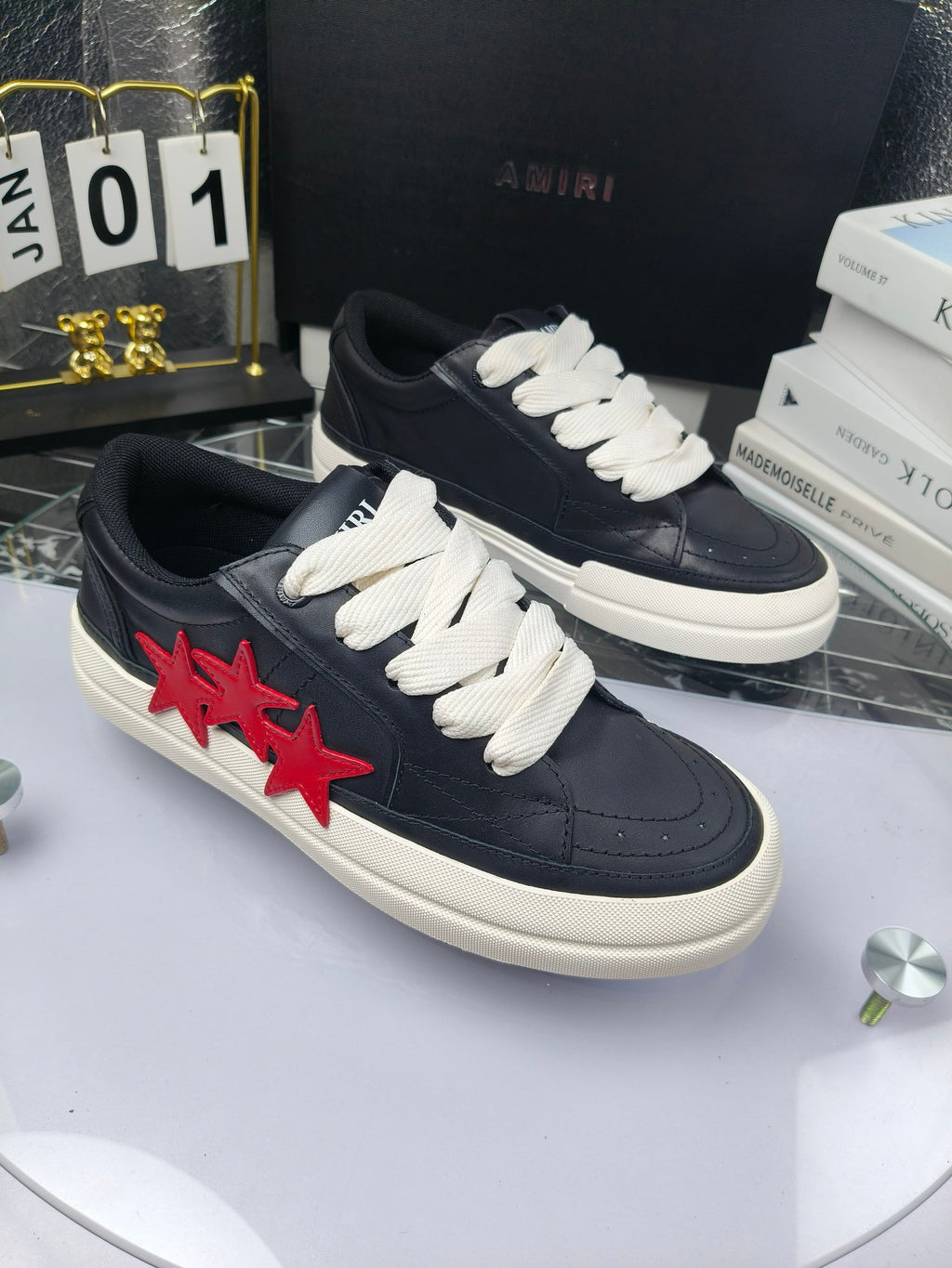 Navy low-top sneakers with white laces and red star applique, angled side view