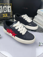 Navy low-top sneakers with white laces and red star applique, angled side view