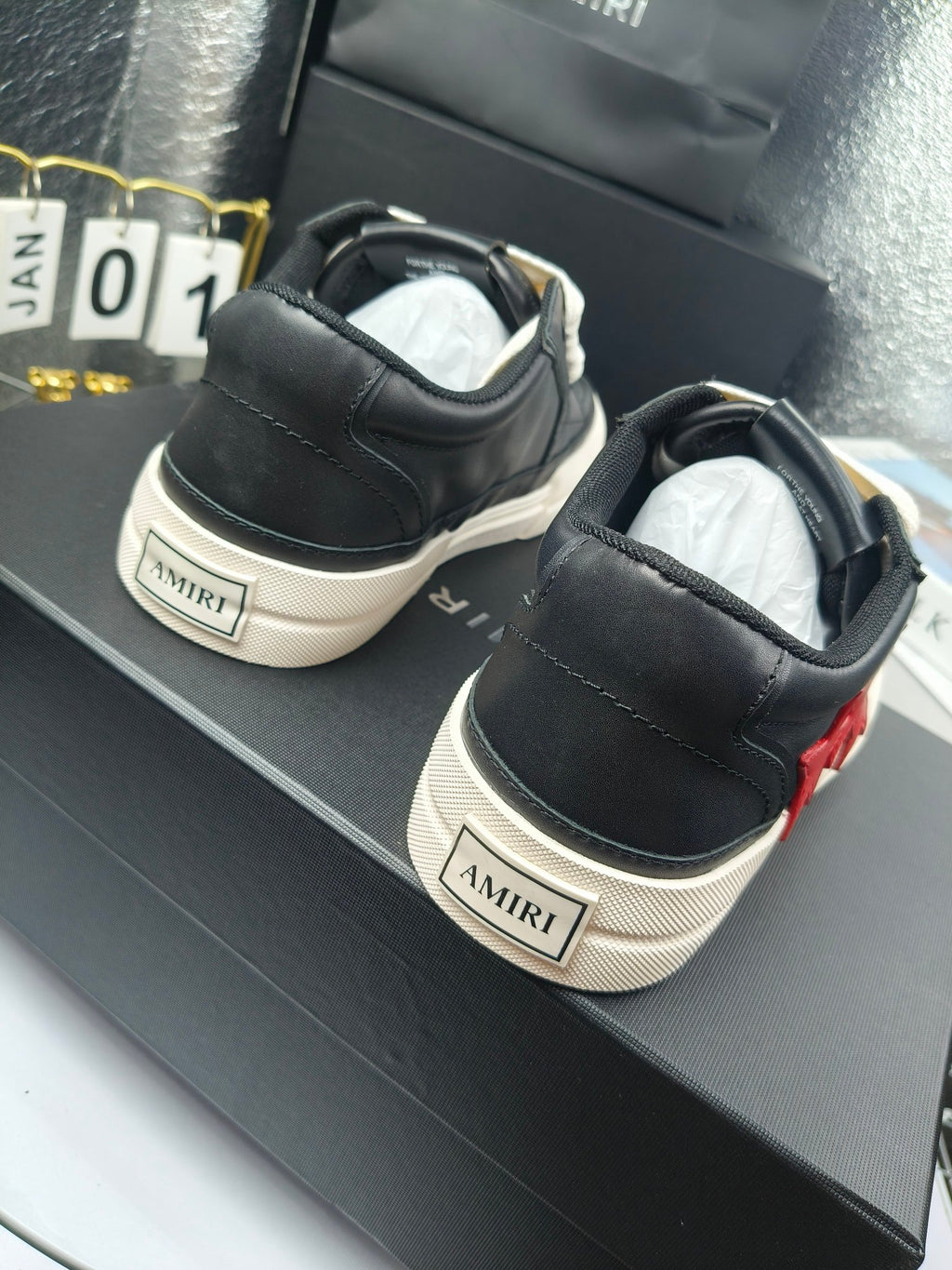 Black sneakers with white logo patch on heel and contrast sole