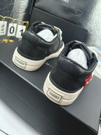 Black sneakers with white logo patch on heel and contrast sole