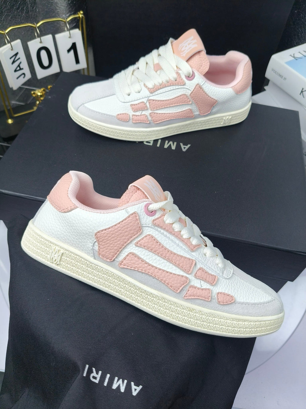Amiri low-top sneakers with white uppers and pink heel and side details, lace-up.