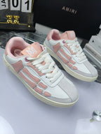 Amiri low-top sneakers, white with pink details and lace-up closure, side view pair.