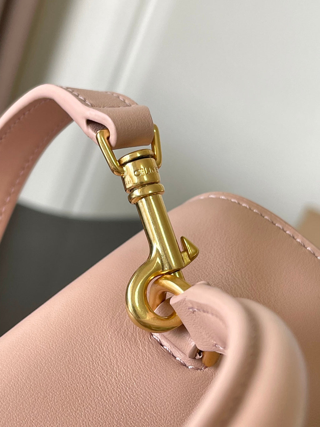 Pale pink handbag handle with gold swivel clasp and leather strap