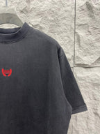 Balenciaga short-sleeve T-shirt shoulder view, dark gray, red logo on front.