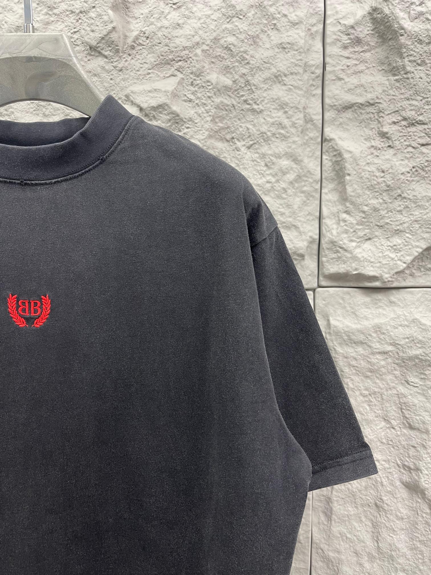 Balenciaga short-sleeve T-shirt shoulder view, dark gray, red logo on front.