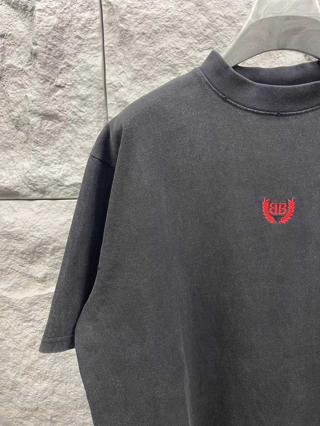 Balenciaga short-sleeve T-shirt close-up, dark gray, red chest logo.