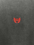 Balenciaga short-sleeve T-shirt fabric close-up, dark gray with red crest logo.