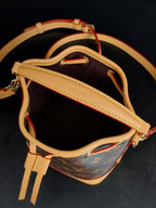 Louis Vuitton monogram bucket bag side view with leather strap and gold-tone clasp