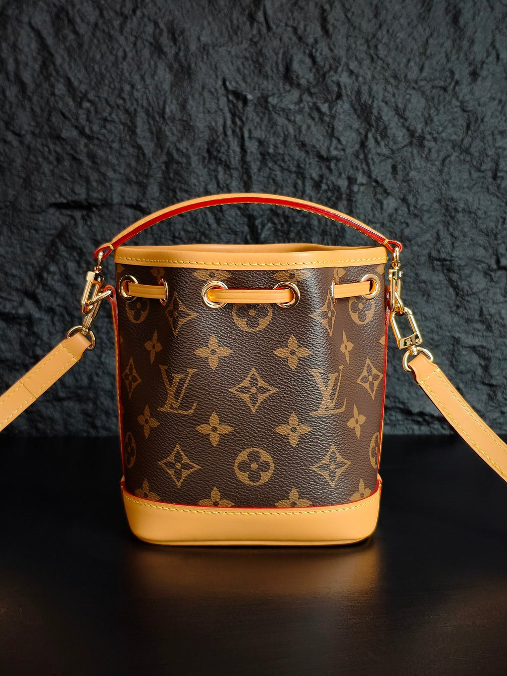 Louis Vuitton monogram bucket bag front view with top handle and shoulder strap
