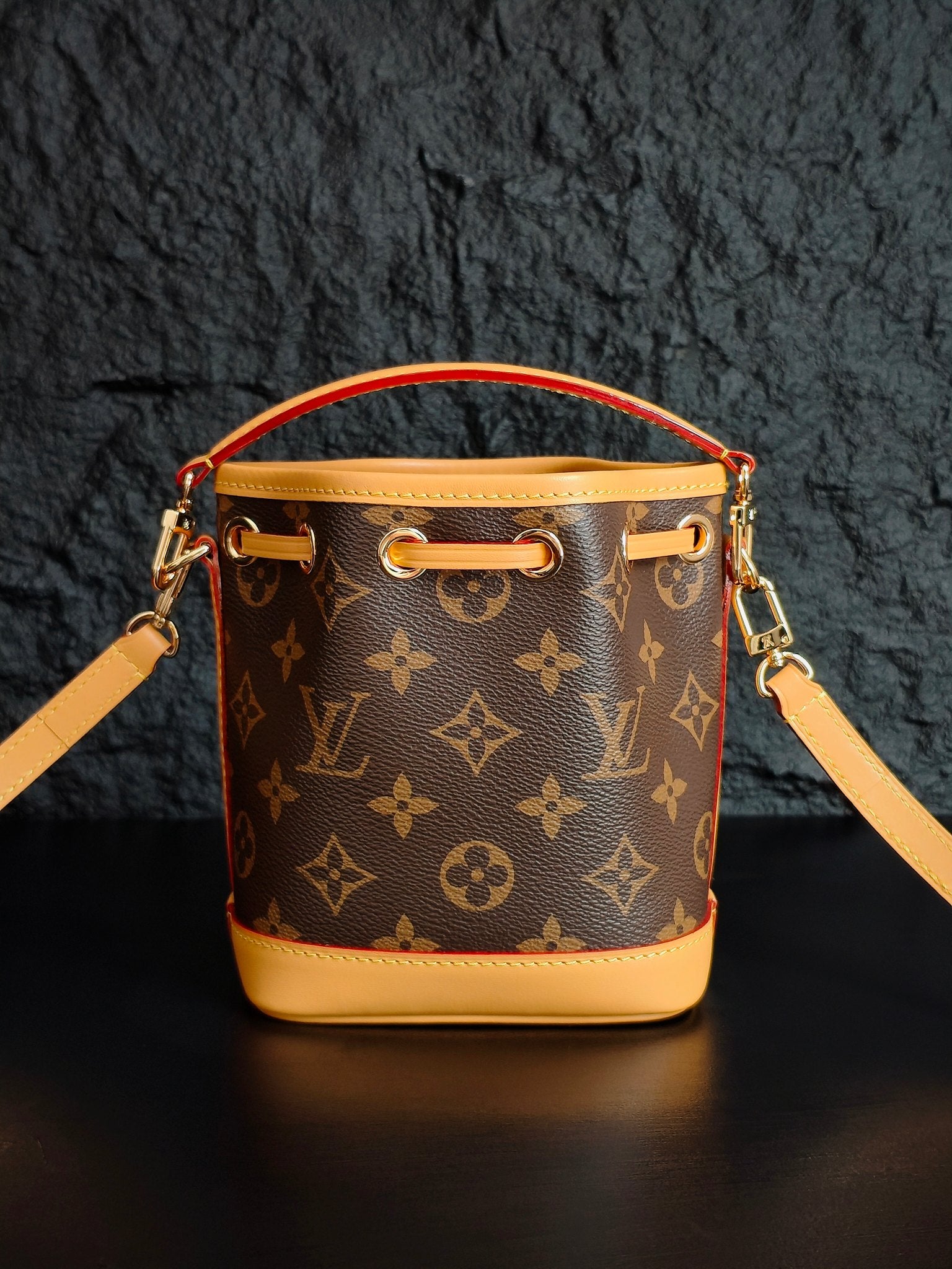 Louis Vuitton monogram bucket bag front view with top handle and shoulder strap