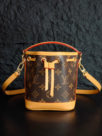 Louis Vuitton monogram bucket bag with crossbody strap and gold-tone rings