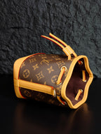 Louis Vuitton monogram bucket bag side view with top handle and red trim accents