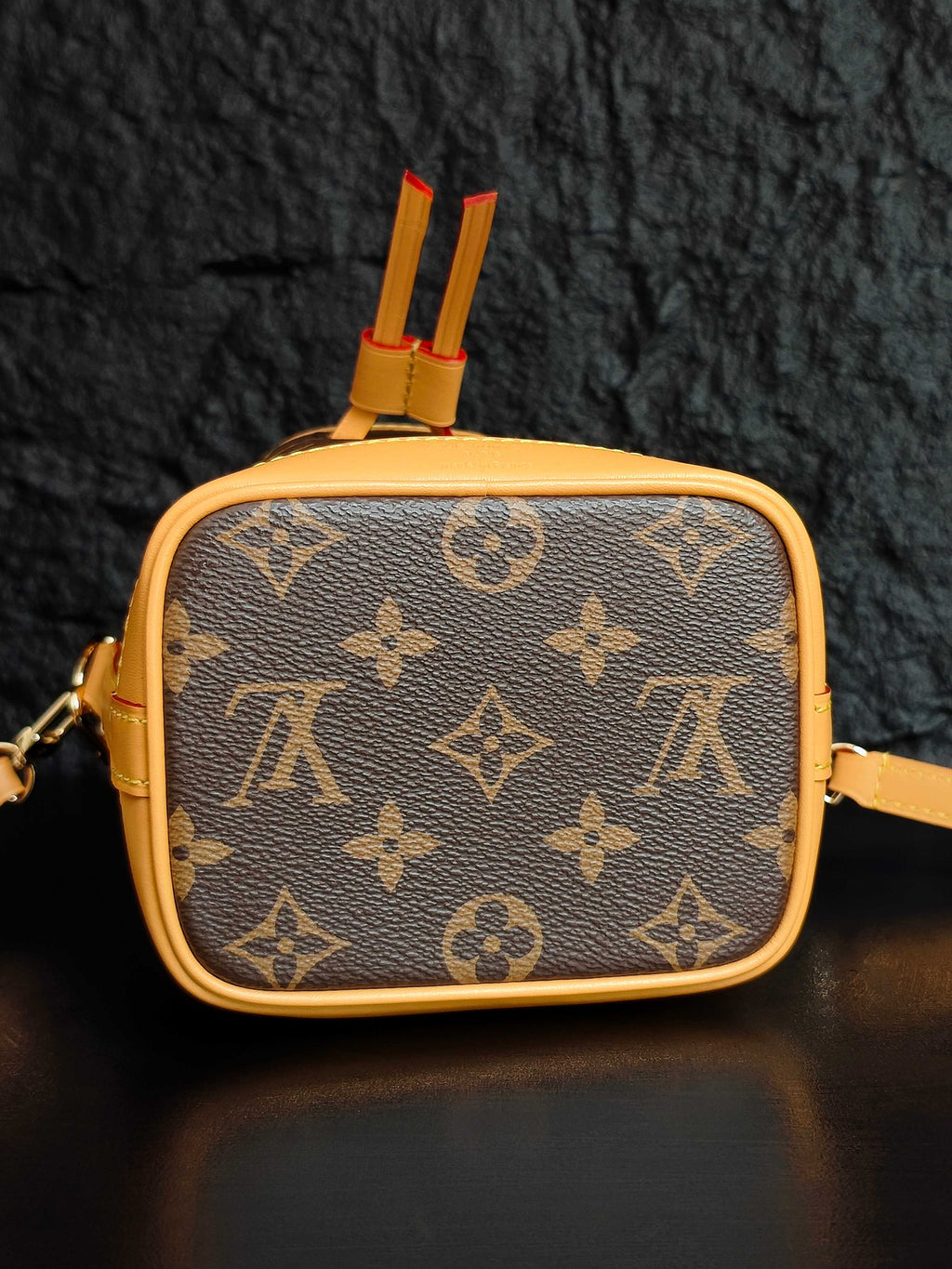 Louis Vuitton monogram mini crossbody bag with top tab detail and red tassel