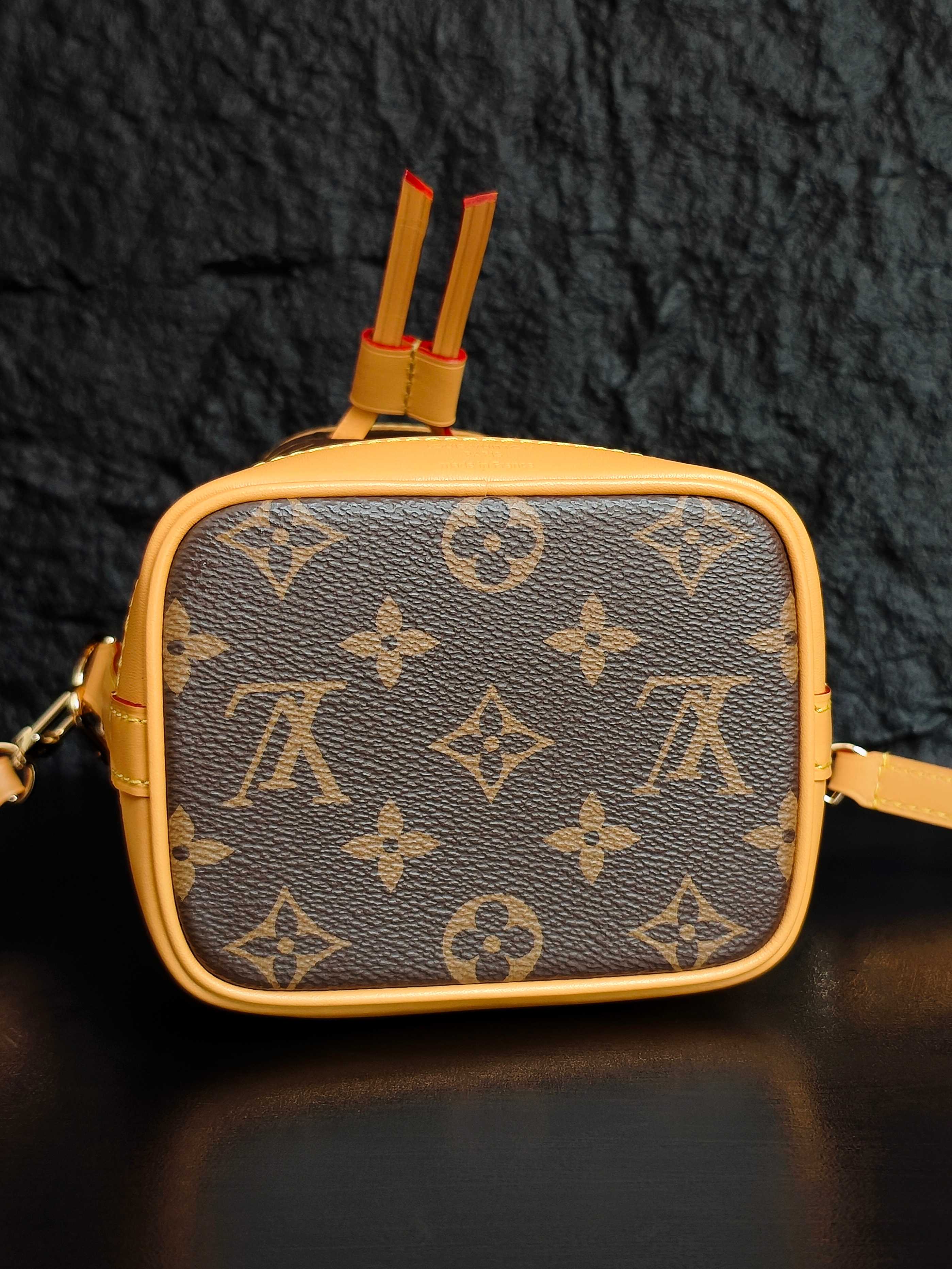 Louis Vuitton monogram mini crossbody bag with top tab detail and red tassel