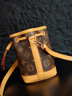 Louis Vuitton monogram bucket bag close-up of strap, buckle, and gold-tone hardware
