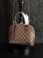 Louis Vuitton handbag in brown checkered canvas with top handles and fur trim