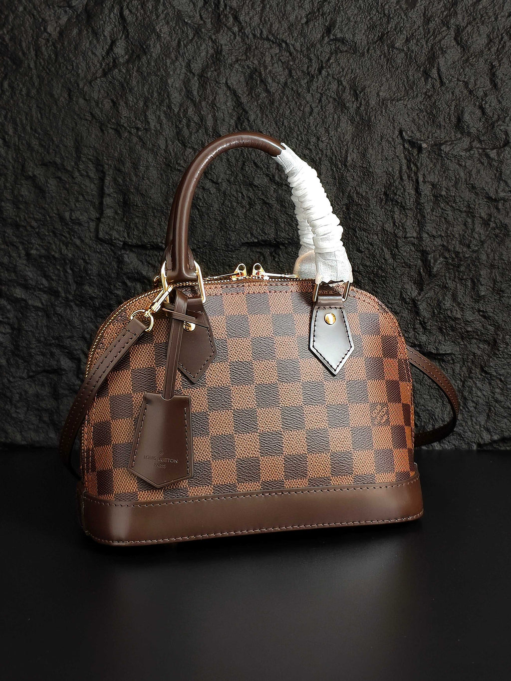 Louis Vuitton handbag with brown checkered canvas, fur-trimmed handle, front pocket details