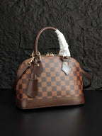 Louis Vuitton handbag with brown checkered canvas, fur-trimmed handle, front pocket details