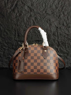 Louis Vuitton handbag in brown checkered canvas with side pockets and fur-trimmed handles