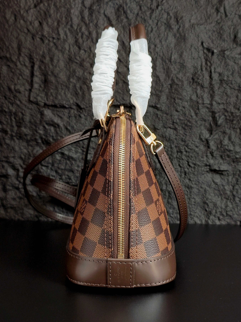 Louis Vuitton handbag from above, brown checkered pattern with zip top and shoulder strap
