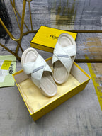 Fendi white slide sandals on yellow box, top view of the pair
