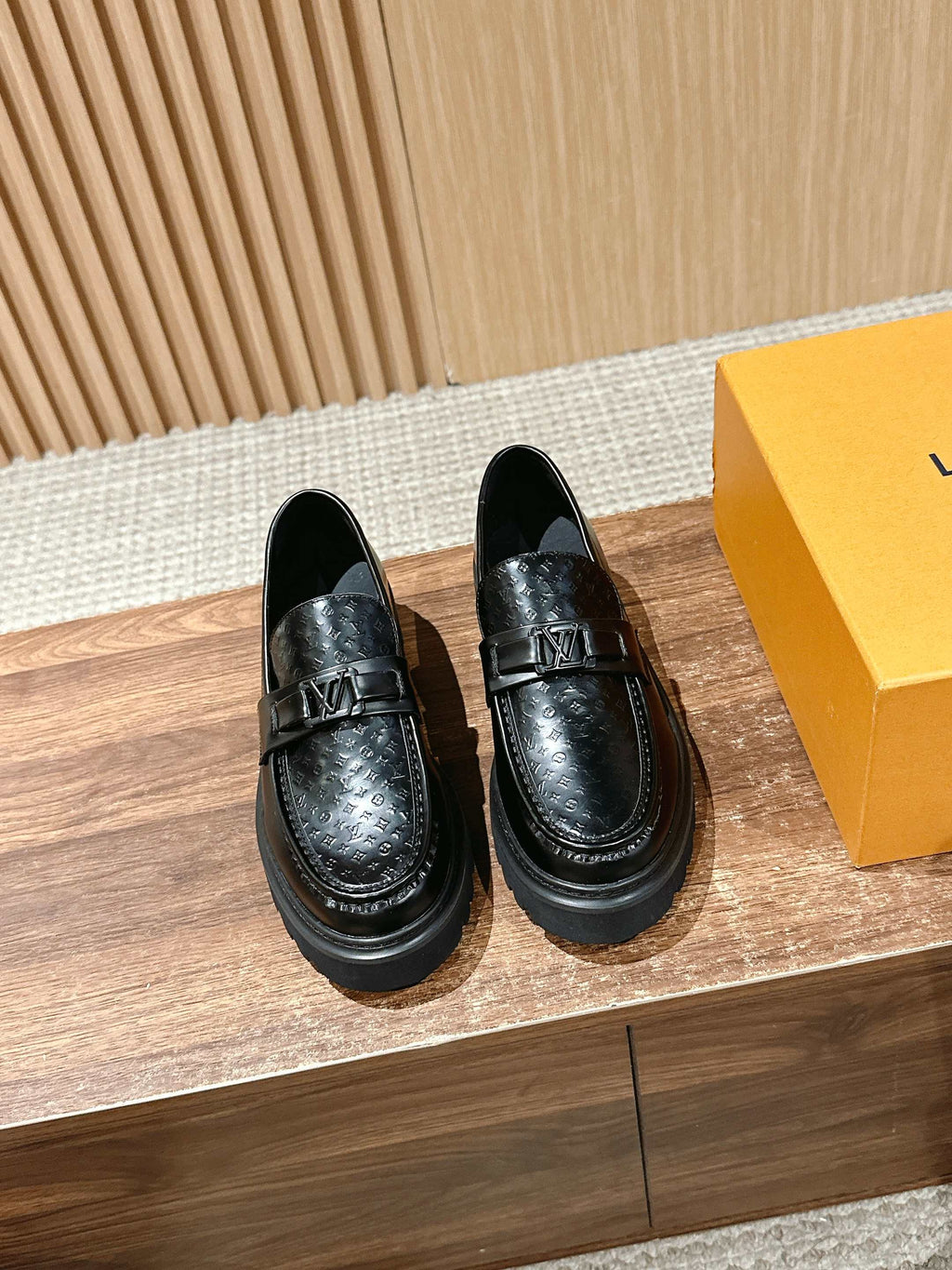 Black leather loafers with embossed monogram detail and slip-on design