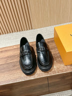 Black leather loafers with embossed monogram detail and slip-on design