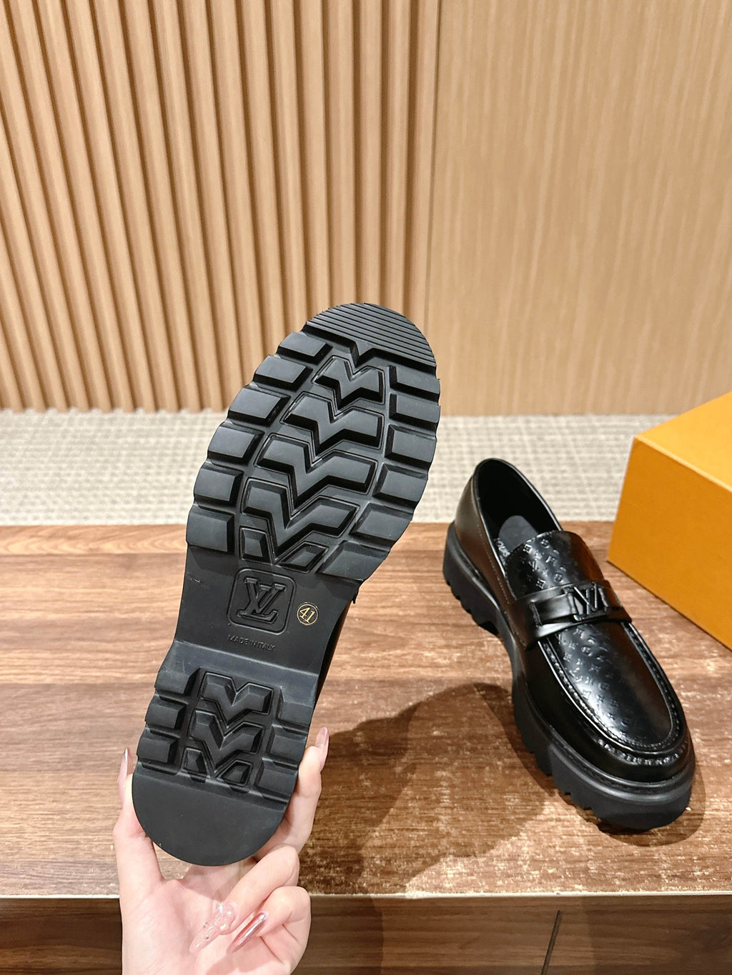 Black loafer sole with tread pattern and embossed logo detail