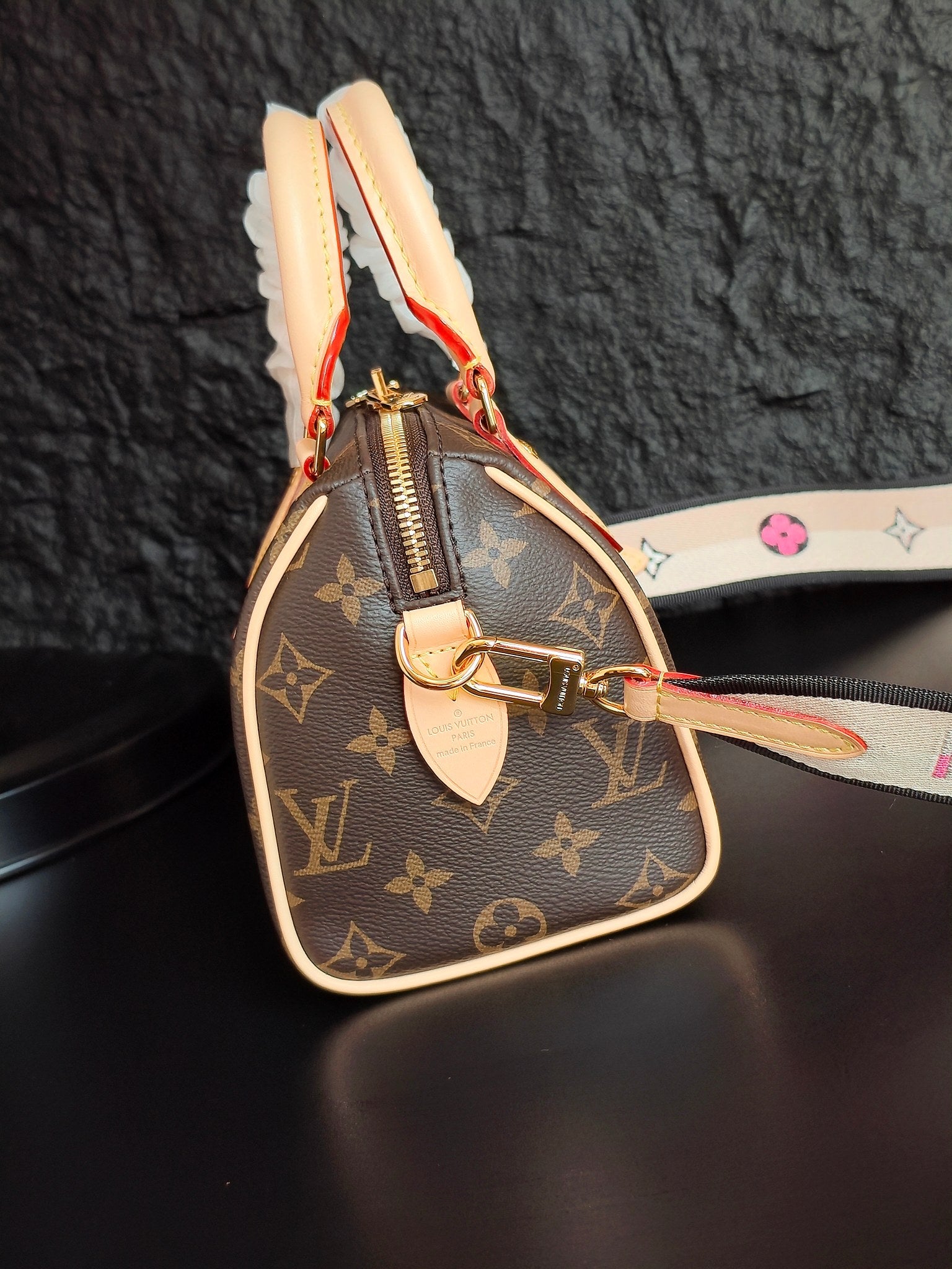 Brown monogram canvas mini handbag with cream leather trim, colorful zipper pull, and side strap