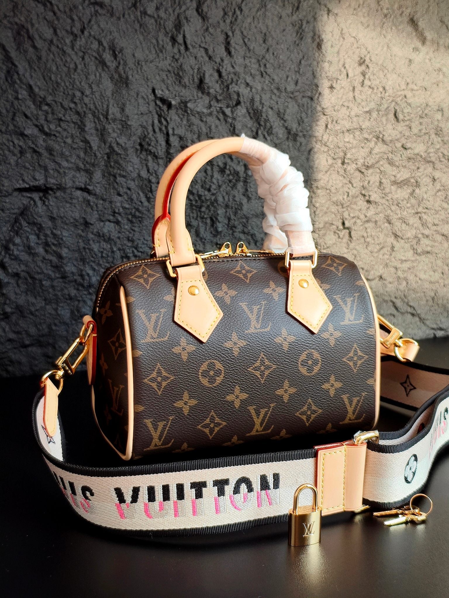 Brown monogram canvas handbag with cream leather handles, ruffled white handle cover, crossbody strap
