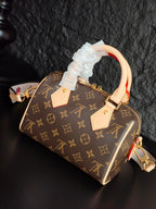 Brown monogram canvas handbag with ruffled white handle cover and cream leather top handles