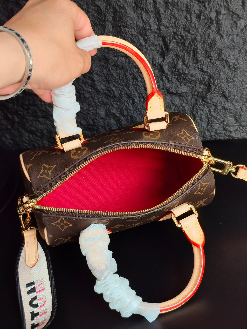 Brown monogram mini handbag with red interior view, cream trim, ruffled handle cover, zipper