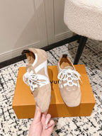 Beige suede sneakers with white laces and triangular side cutout detail