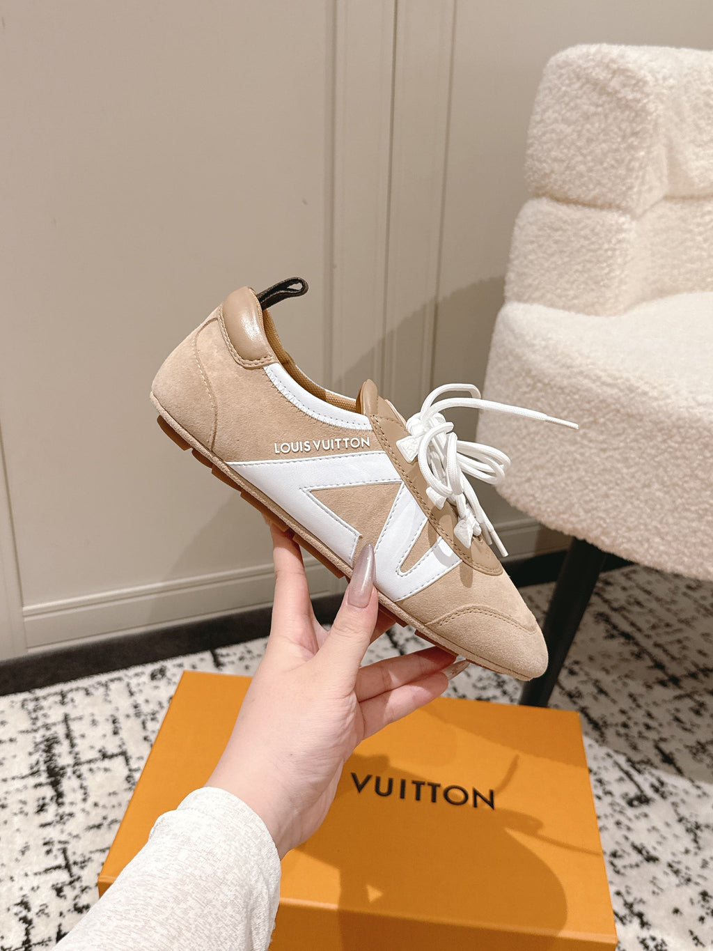 Beige suede sneakers with white laces, dark pull tab, and contrast side panel
