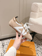 Beige suede sneakers with white laces, dark pull tab, and contrast side panel