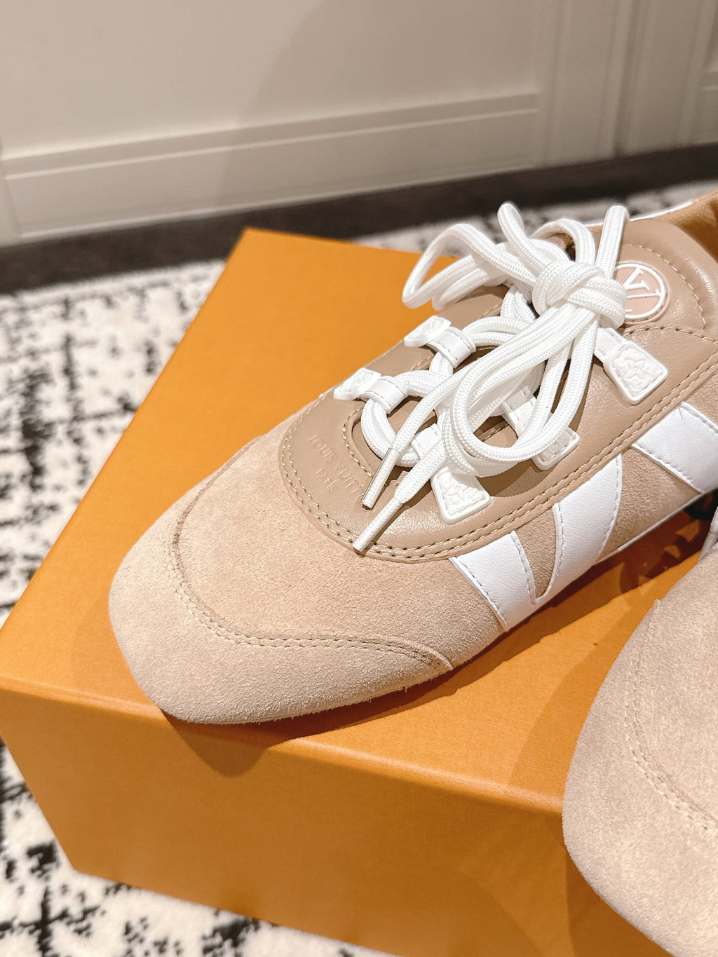 Close-up beige suede sneaker with white laces and white leather side stripe