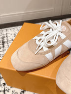 Close-up beige suede sneaker with white laces and white leather side stripe