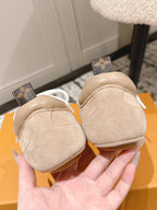 Beige suede sneakers with white laces and brown monogram heel tabs at back