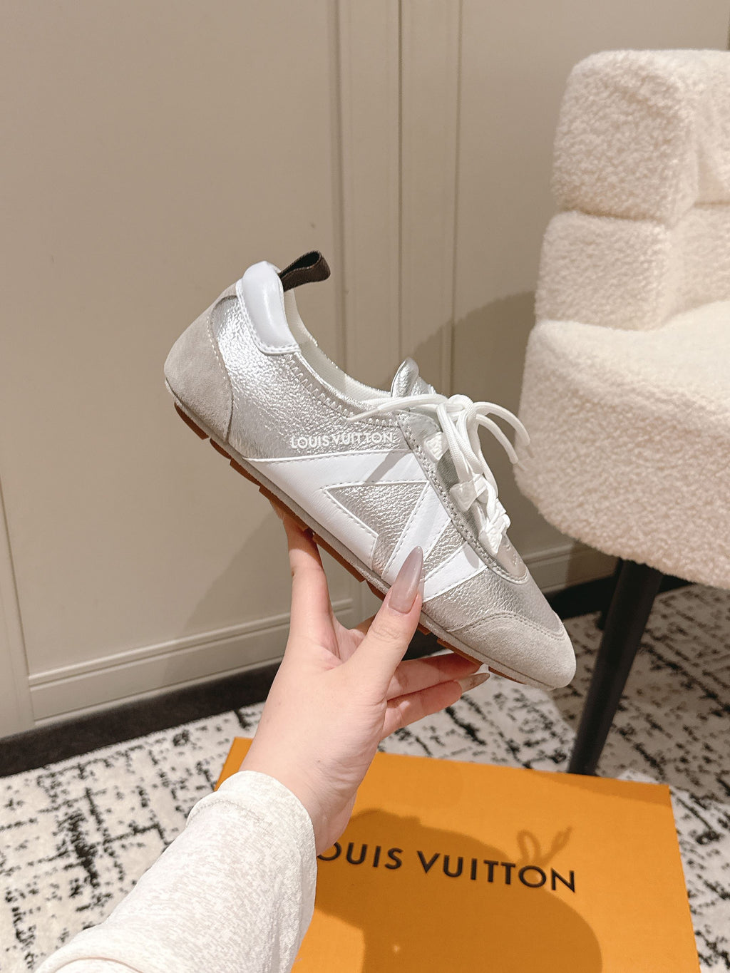 Louis Vuitton low-top sneakers in metallic silver, side profile with white laces